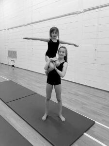 Girl holding up another